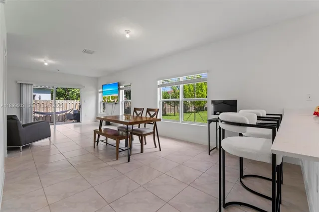 a dining room with furniture and a floor to ceiling window