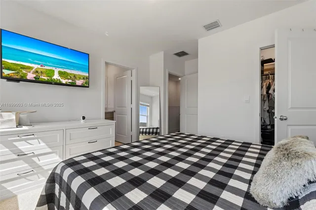 a bedroom with a bed and a lamp on dresser