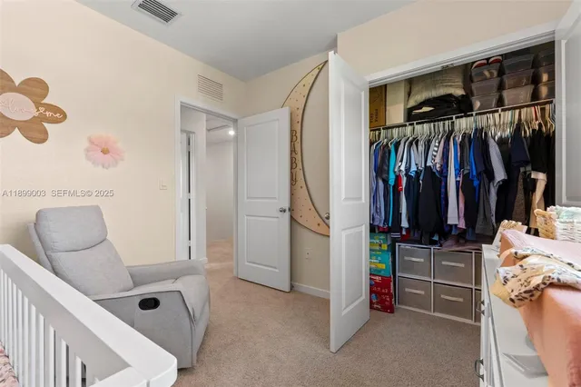 a view of walk in closet with clothes and shoes