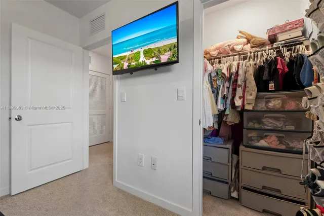 a view of walk in closet with clothes