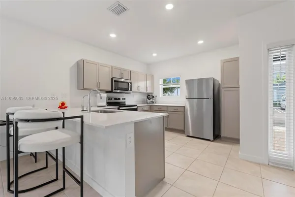 a kitchen with a refrigerator a microwave a stove and a cabinets