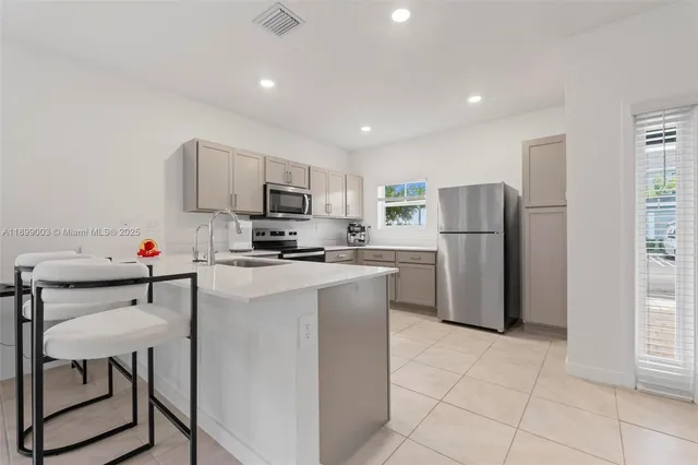 a kitchen with a refrigerator and a stove top oven