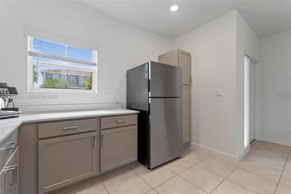 a kitchen with a refrigerator sink and cabinets