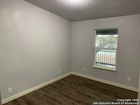 an empty room with wooden floor and a window