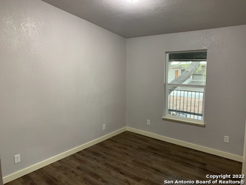 520 Gentleman Road, Unit 4 Balcones Heights, TX 78201 - Photo 8 of 13 an empty room with wooden floor and a window