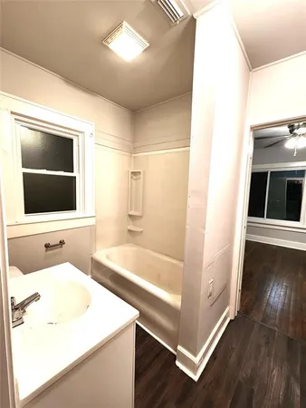 a bathroom with a sink a large mirror and bathtub