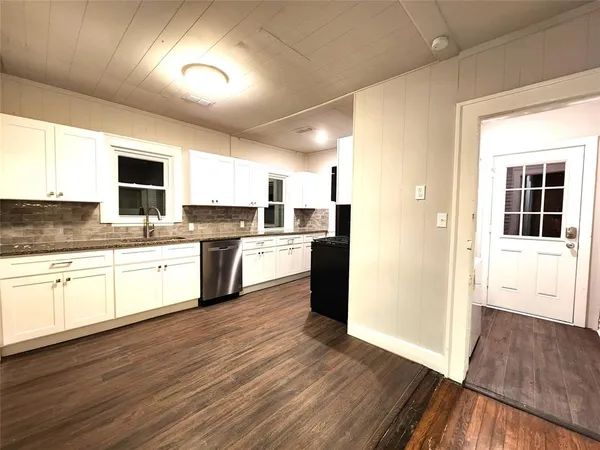 a kitchen with granite countertop a refrigerator and a stove top oven
