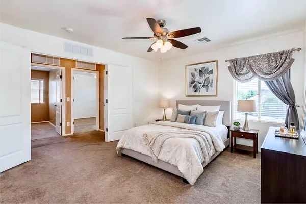 a spacious bedroom with a bed and a large mirror