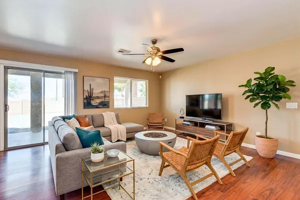 a living room with furniture a flat screen tv and a potted plant