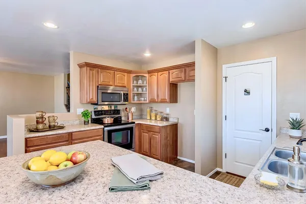 a kitchen with a stove a refrigerator and a wooden cabinets