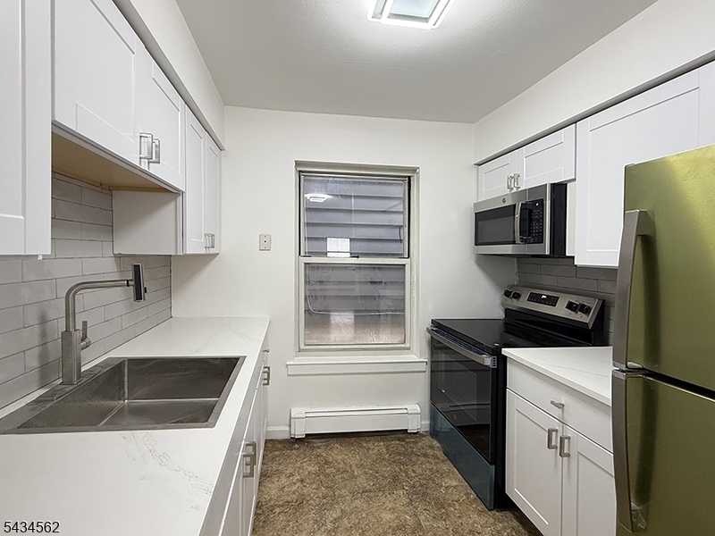 19 Van Rensselear Street, Unit 2 Belleville, NJ 07109 - Photo 3 of 7 a kitchen with a refrigerator stove and sink