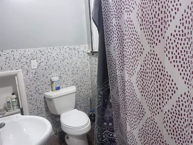 a white toilet sitting next to a white wall