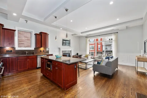 a kitchen with stainless steel appliances granite countertop a sink and wooden floors