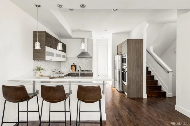 a kitchen with stainless steel appliances kitchen island granite countertop a table chairs and white cabinets