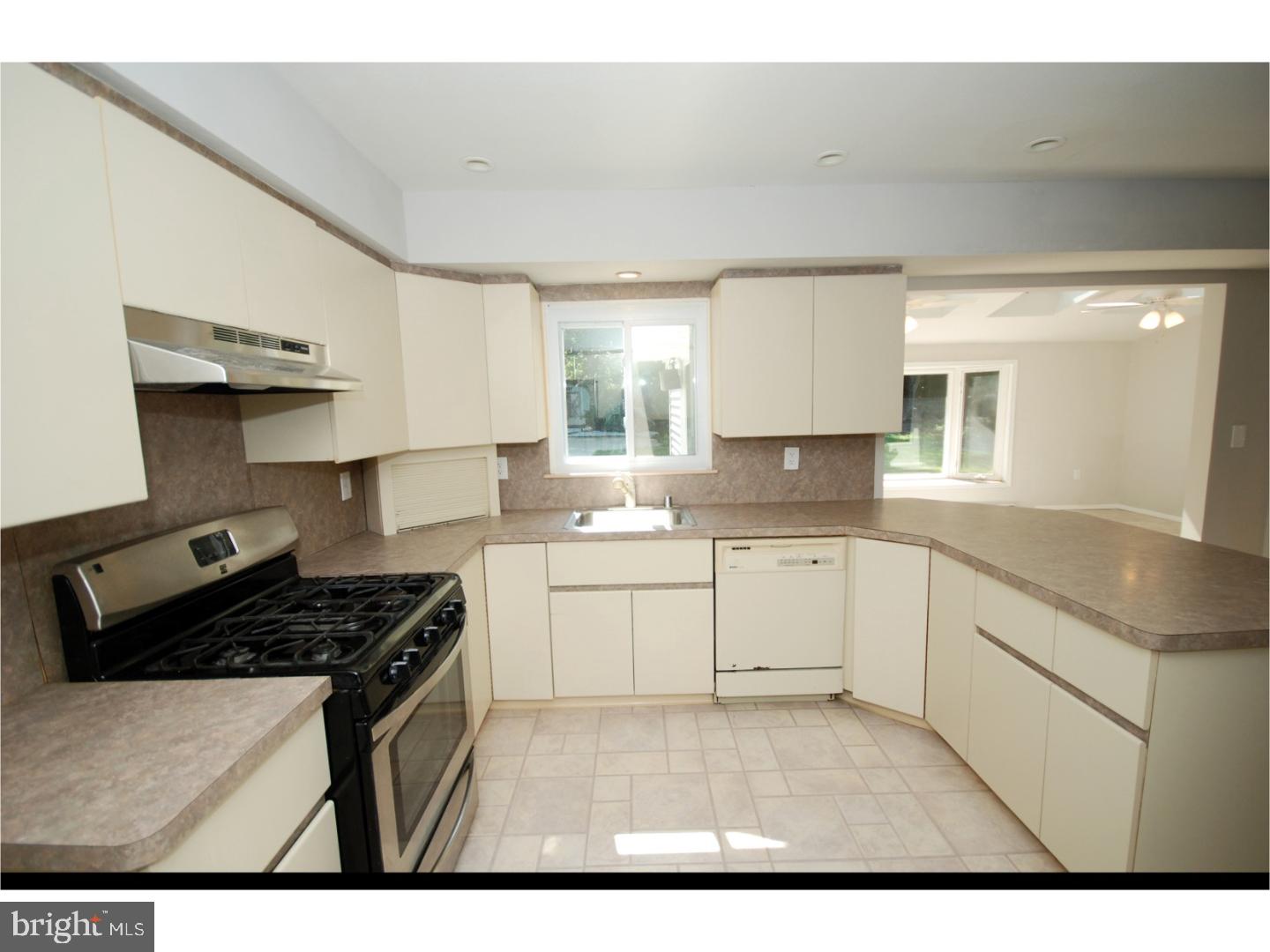 39 Lexington Road Freehold, NJ 07728 - Photo 3 of 24 a kitchen with a stove a sink and a refrigerator