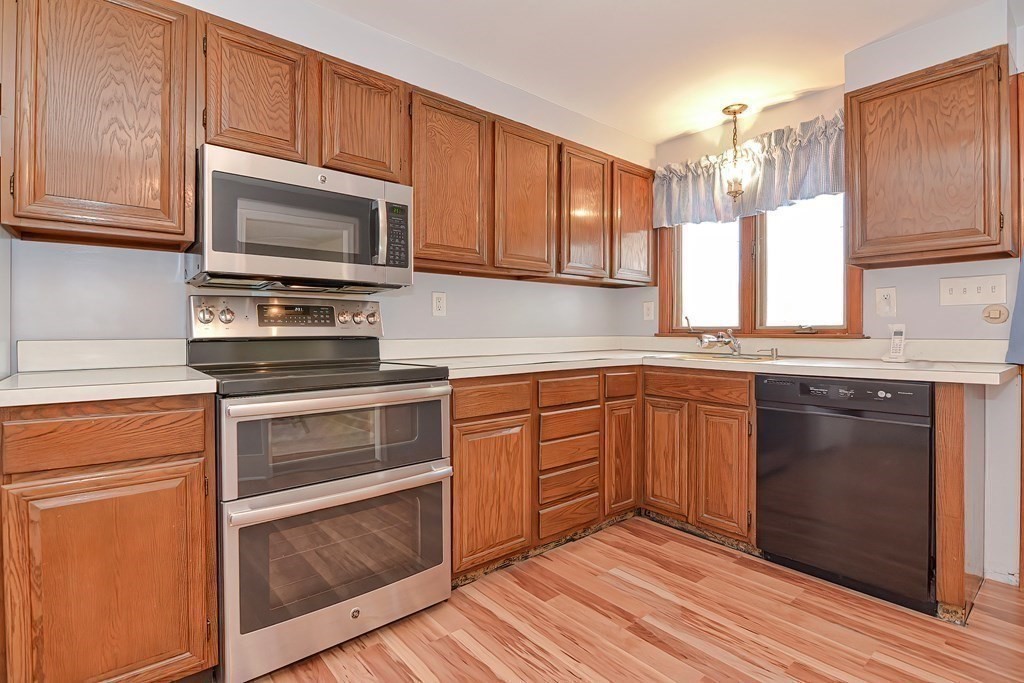 39 Dolan Road Millbury, MA 01527 - Photo 10 of 27 a kitchen with stainless steel appliances granite countertop a stove microwave and cabinets