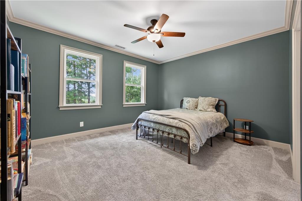 632 Geiger Road Jefferson, GA 30549 - Photo 40 of 55 a spacious bedroom with a bed and a ceiling fan