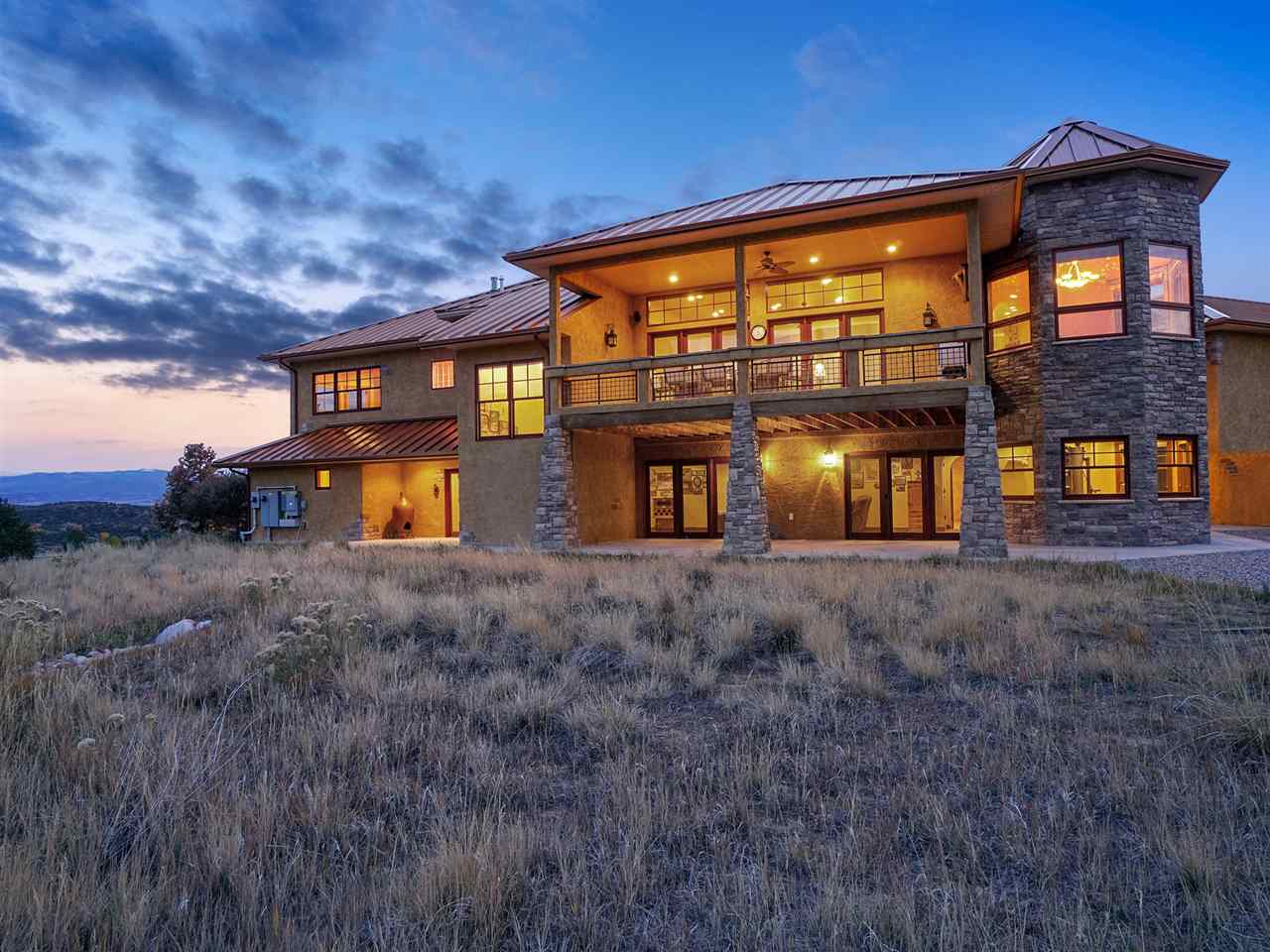 966 Mesa Drive Rifle, CO 81650 - Photo 27 of 31 a view of a big house with large windows and a yard