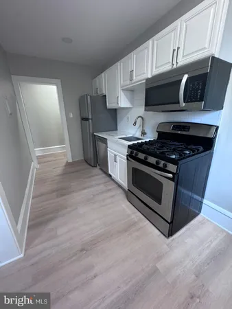 a kitchen with granite countertop wooden cabinets and a stove top oven