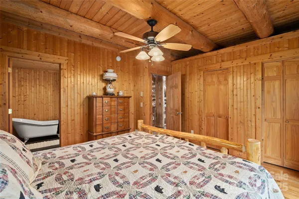 a bedroom with a bed chandelier and a window