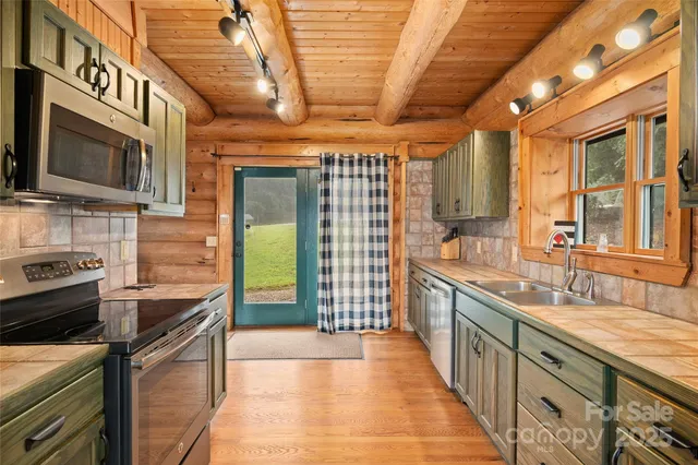 a kitchen with stainless steel appliances granite countertop a sink a stove and cabinets