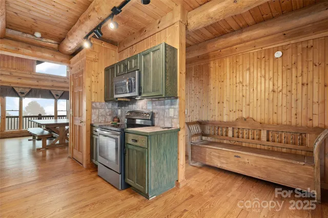 a kitchen with microwave a stove and cabinets