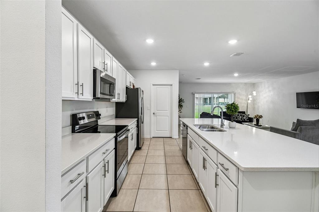 136 Citrine Loop Kissimmee, FL 34758 - Photo 2 of 28 a large kitchen with stainless steel appliances lots of counter space sink and cabinets