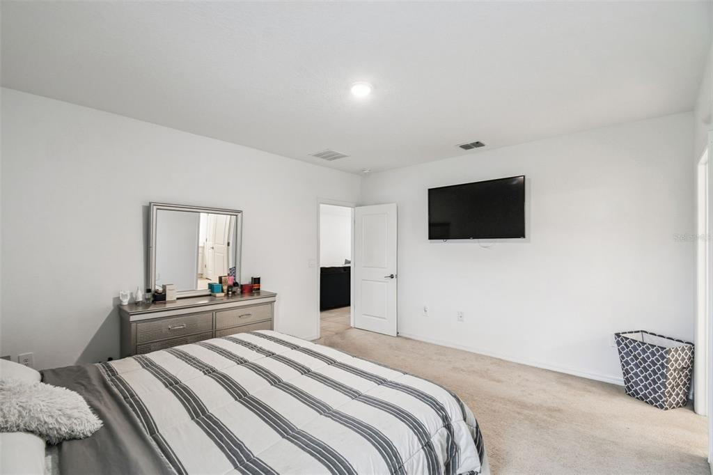 136 Citrine Loop Kissimmee, FL 34758 - Photo 21 of 28 a bedroom with a bed and a flat screen tv