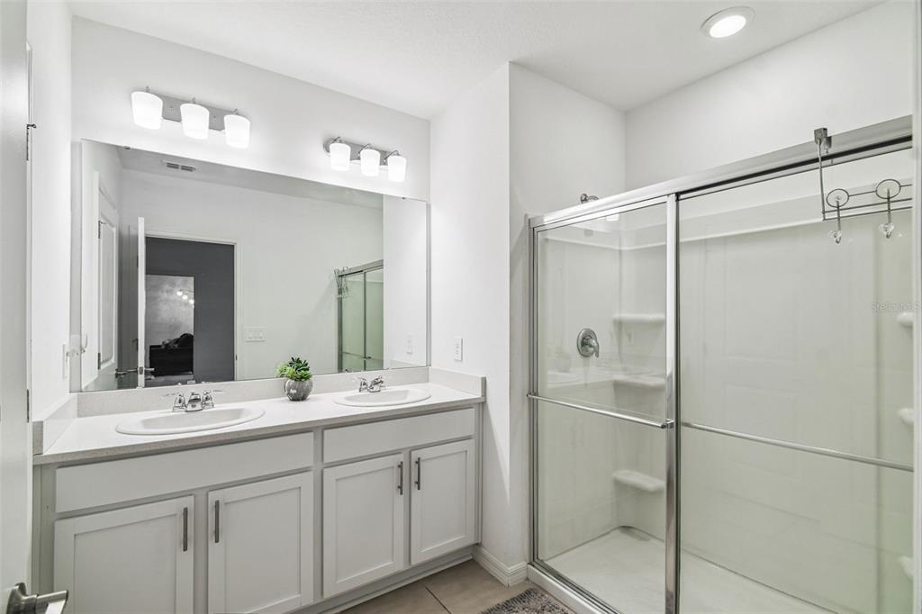 136 Citrine Loop Kissimmee, FL 34758 - Photo 23 of 28 a bathroom with a double vanity sink mirror and shower