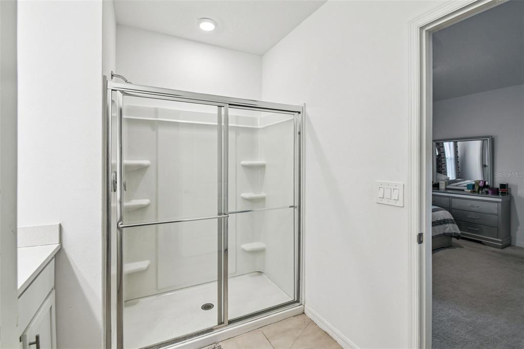 136 Citrine Loop Kissimmee, FL 34758 - Photo 24 of 28 a bathroom with a glass shower door