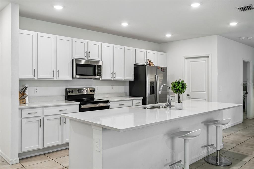 136 Citrine Loop Kissimmee, FL 34758 - Photo 3 of 28 a kitchen with appliances a sink cabinets and a counter top space