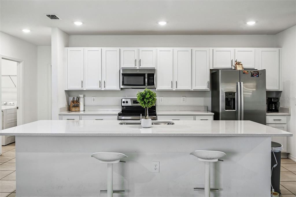 136 Citrine Loop Kissimmee, FL 34758 - Photo 4 of 28 a kitchen with kitchen island a counter top space cabinets and stainless steel appliances