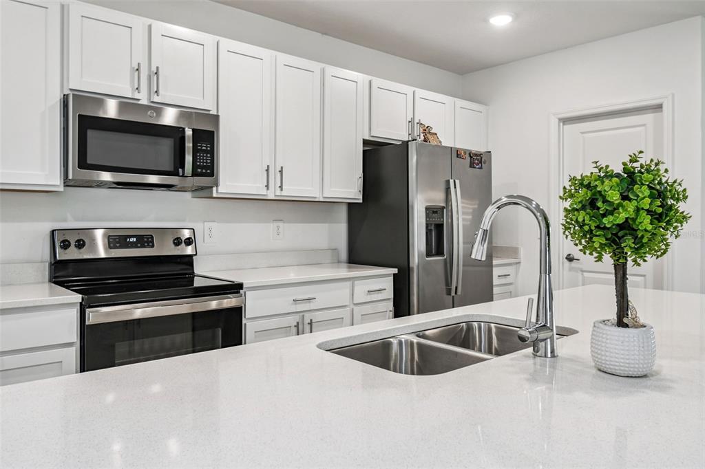 136 Citrine Loop Kissimmee, FL 34758 - Photo 8 of 28 a kitchen with stainless steel appliances a stove a sink a microwave and cabinets