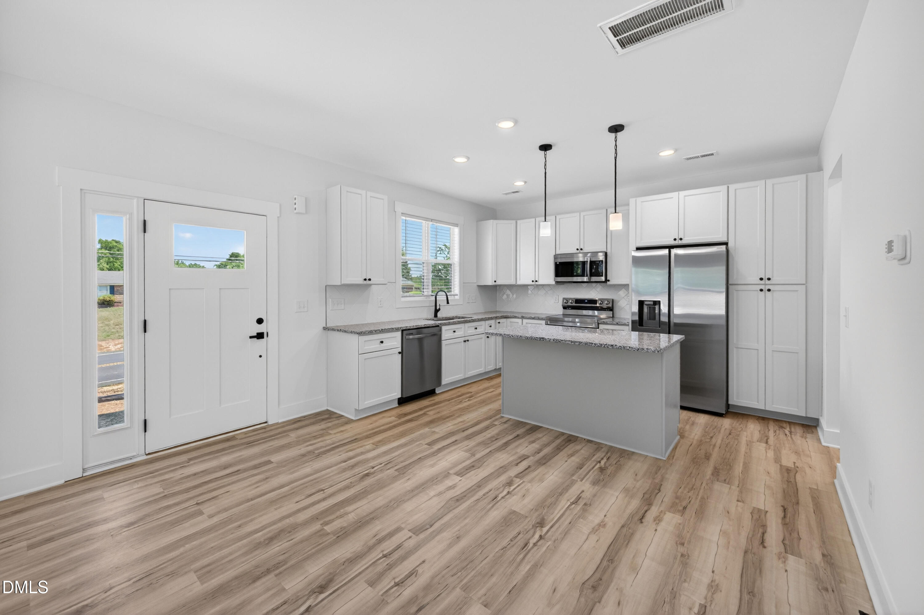 1182 Hurdle Mills Road Roxboro, NC 27573 - Photo 8 of 45 a kitchen with stainless steel appliances granite countertop a refrigerator a sink dishwasher a stove and white countertops with wooden floor