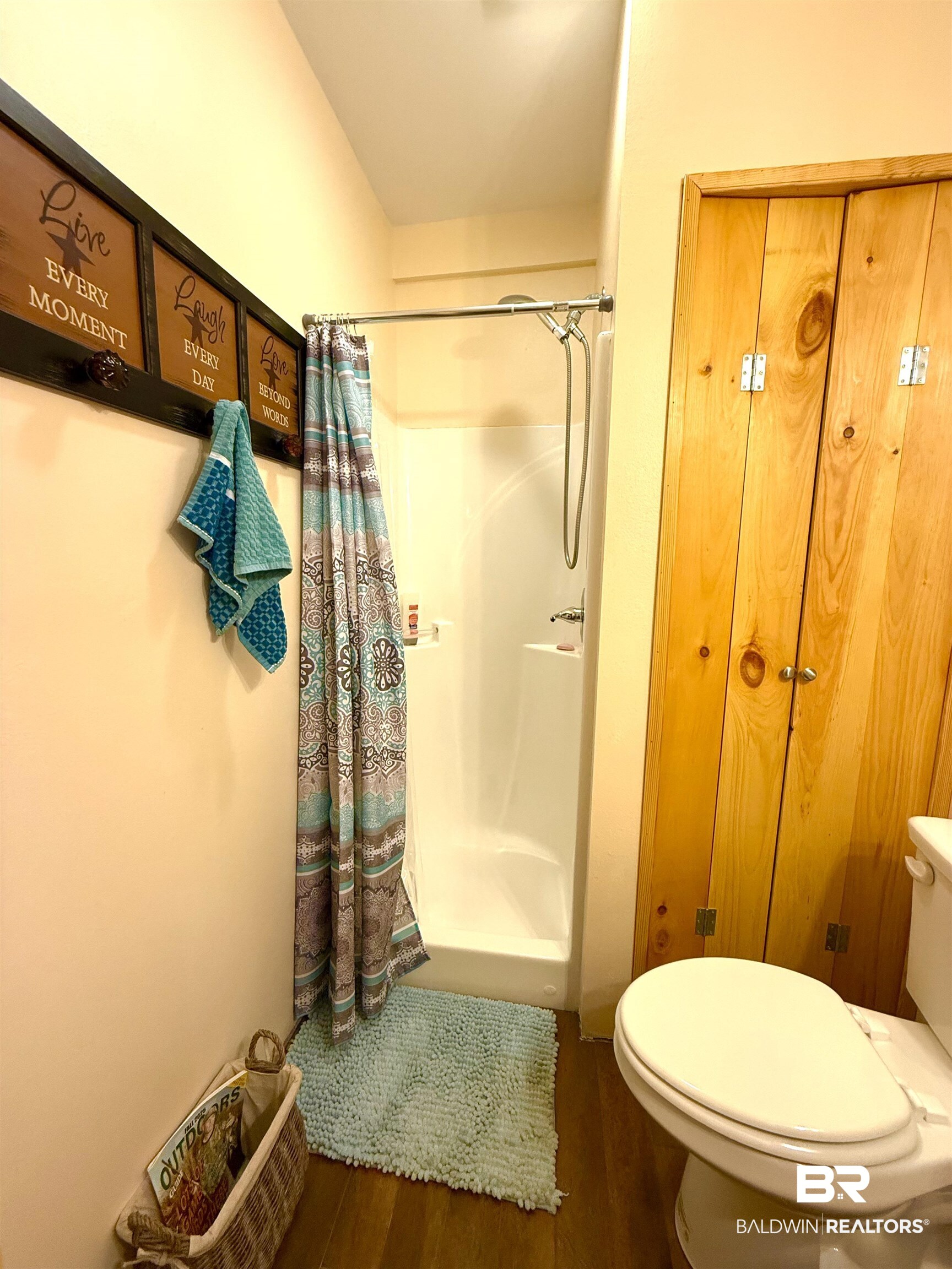 1 Mason Ferry Road Citronelle, AL 36522 - Photo 11 of 40 Three-piece bathroom featuring a shower stall with a white base, wood-finish flooring, and natural wood bi-fold doors