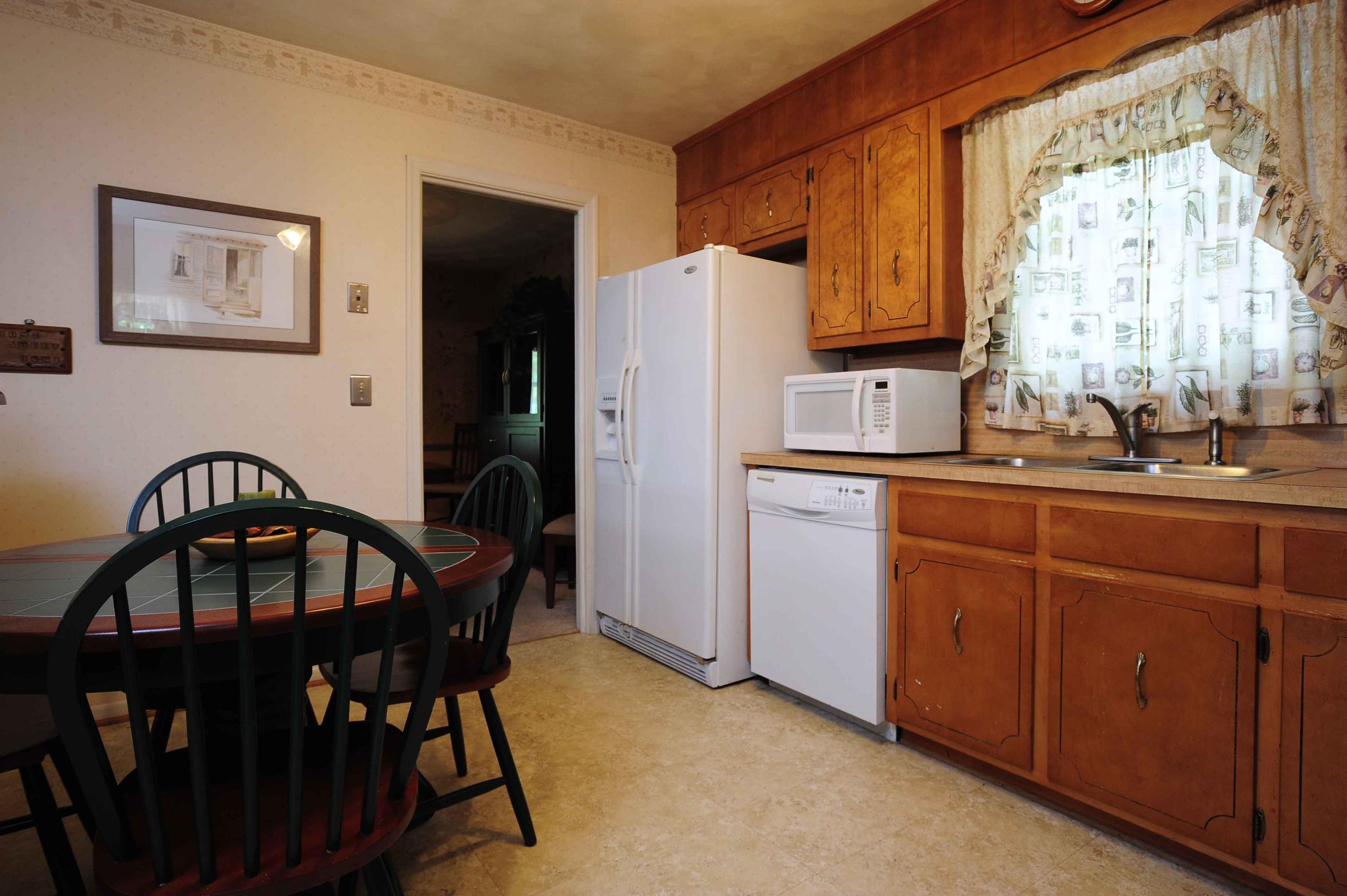 302 Pin Oak Drive Blue Ridge, VA 24064 - Photo 13 of 18 a kitchen with stainless steel appliances a table chairs and a refrigerator