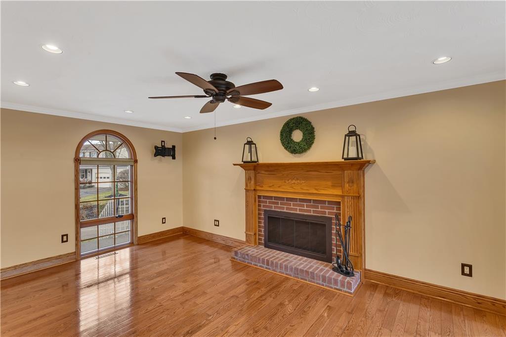 210 Gotham Lane Monroeville, PA 15146 - Photo 14 of 31 an empty room with wooden floor a fireplace and a large window