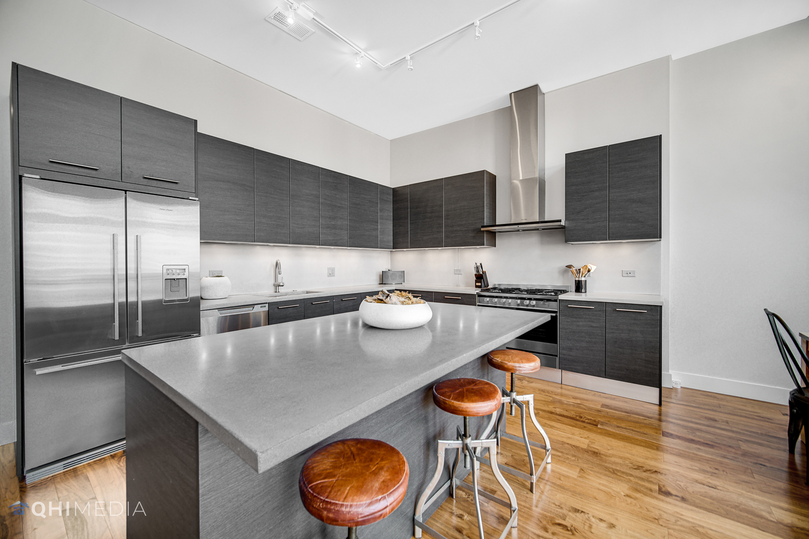 16 North Carpenter Street, Unit PHN Chicago, IL 60607 - Photo 7 of 25 a kitchen with stainless steel appliances granite countertop a sink a stove and a refrigerator