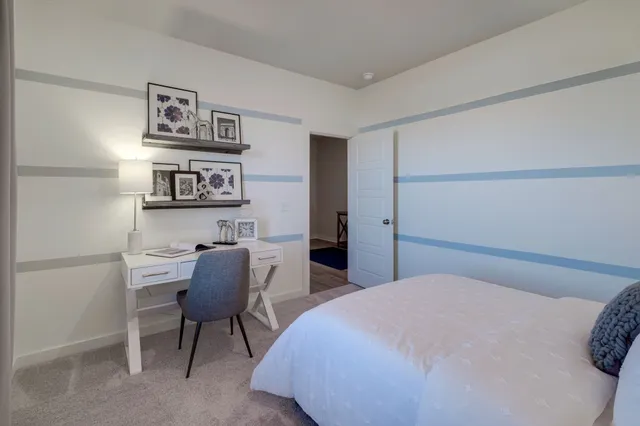 a bedroom with a bed and a chair in it