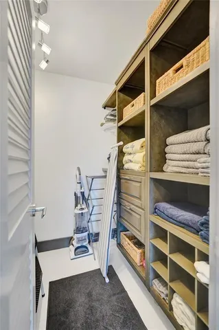 a view of walk in closet with clothes and shoes