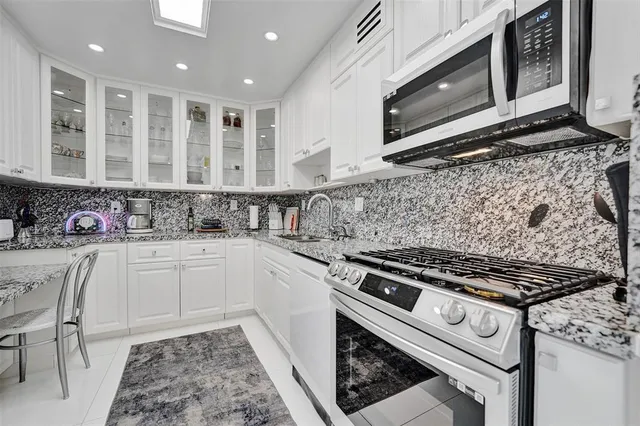 a kitchen with stainless steel appliances granite countertop a stove and a microwave