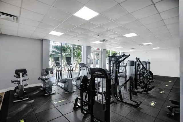 a room with gym equipment and large windows