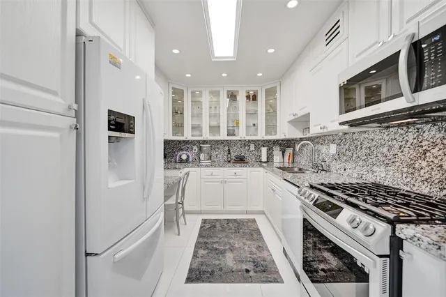 a kitchen with stainless steel appliances granite countertop a refrigerator and a stove