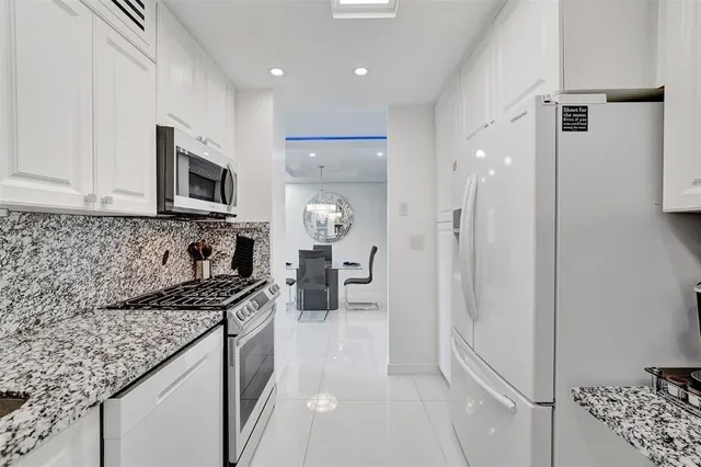 a kitchen with a refrigerator and a counter top space