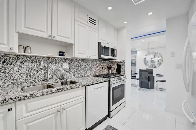 a kitchen with stainless steel appliances granite countertop a sink and a stove
