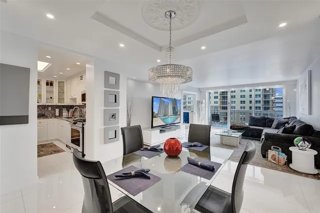 a living room with furniture kitchen view and a large window