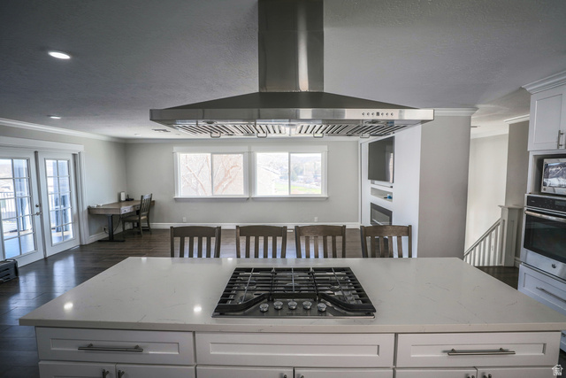 422 West Buckeye Reef Road Leeds, UT 84746 - Photo 18 of 47 Main Kitchen featuring white cabinetry, crown molding, light stone countertops, stainless steel appliances, and dark wood-type flooring