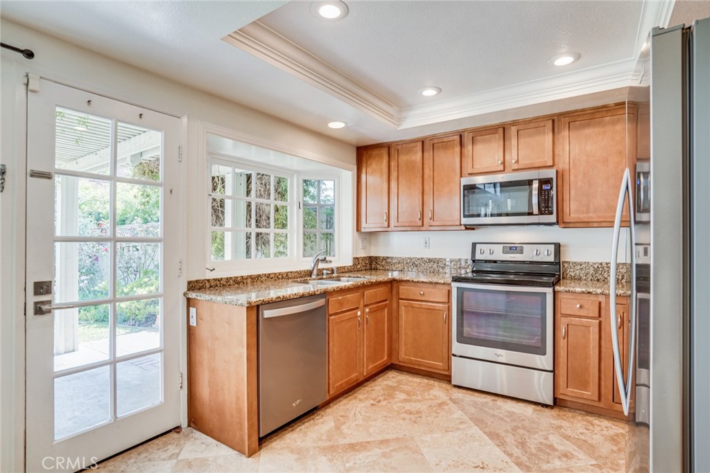 49 East Yale Loop, Unit 26 Irvine, CA 92604 - Photo 12 of 63 a kitchen with stainless steel appliances granite countertop a stove top oven