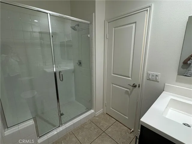 a bathroom with a double vanity sink a toilet and shower
