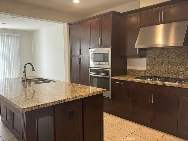 a kitchen with granite countertop a sink and stainless steel appliances